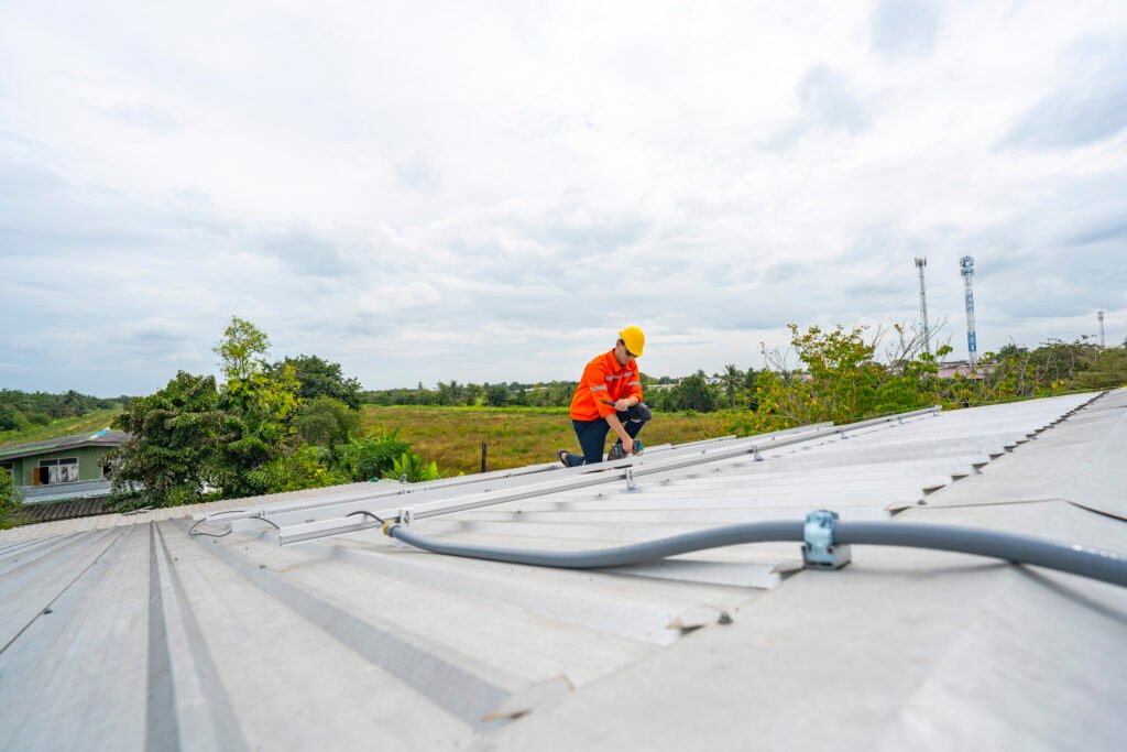 technician in safety uniform and helmet kneeling on a rooftop, u technician in safety uniform and helmet kneeling on a rooftop, u